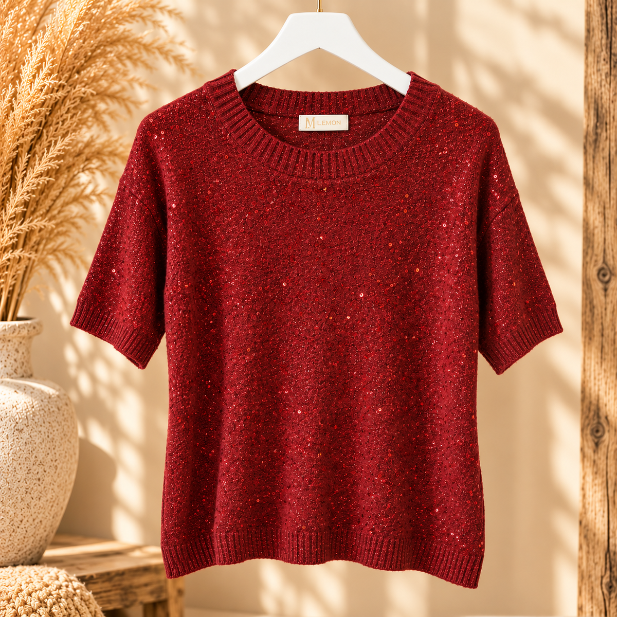 Bordeaux rode gebreide trui met korte mouwen en glitter details op een kledinghanger