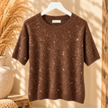 Bruine gebreide trui met korte mouwen en glitter details op een kledinghanger