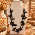 Zwarte dubbele statement ketting met bladvormige accenten en gouden skakels op buste – EllesDelanaStyle