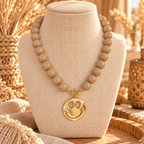Korte kralenketting in beige met een gouden smiley hanger van EllesDelanaStyle