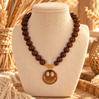 Korte kralenketting in bruin met een gouden smiley hanger van EllesDelanaStyle